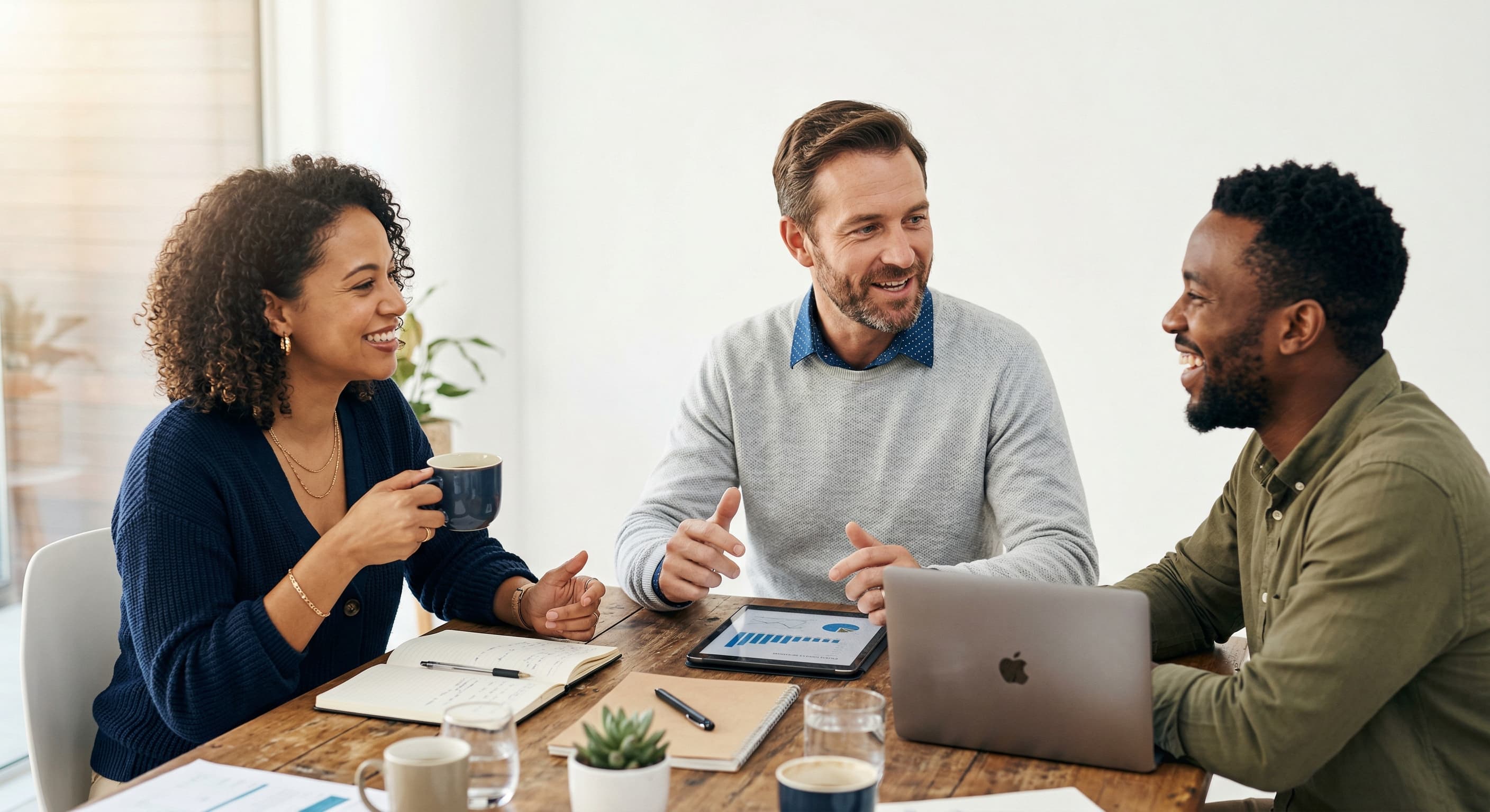 Pessoas reunidas analisando uma estratégia em frente ao laptop